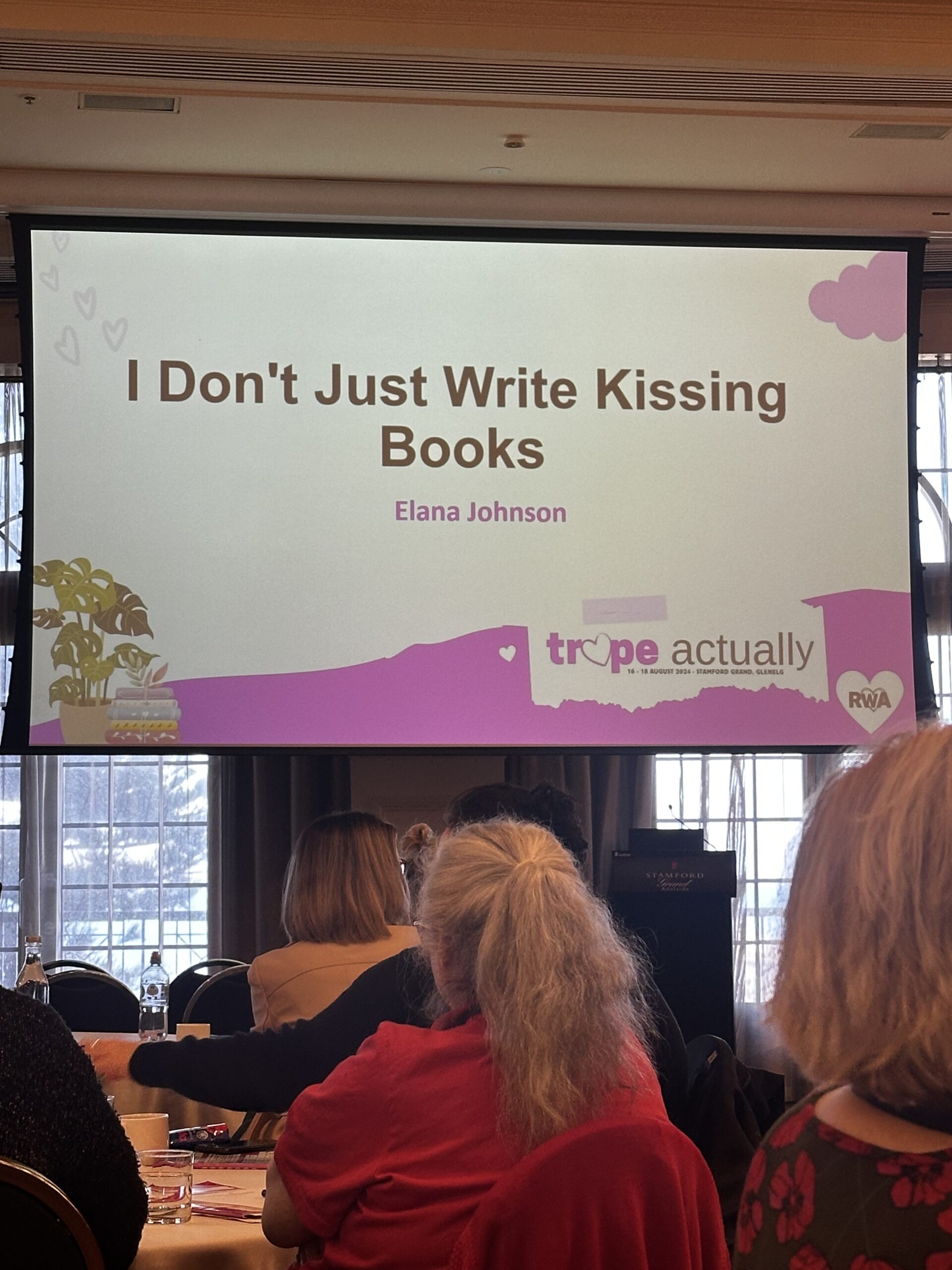 Slide with 'I don't just write kissing books' title by Elana Johnson, 2024 Trope Actually RWA  Conference. 